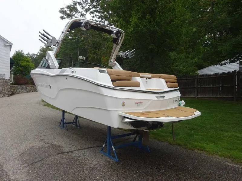Slide: The Image of 2022 MasterCraft XT23 boat on stands, rear view, white exterior, tan interior. - 6