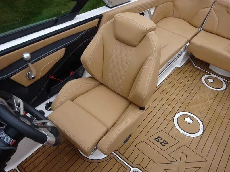 Slide: The Image of 2022 MasterCraft XT23 boat interior with tan leather seats and teak flooring. - 9