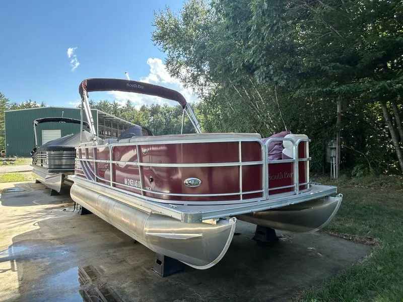 Slide: The Image of 2012 South Bay 518 CR pontoon boat in red, docked on a concrete pad. - 0