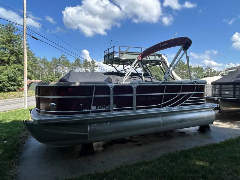 Slide: The Image of 2012 South Bay 518 CR pontoon boat with canopy, parked on a driveway. - 15