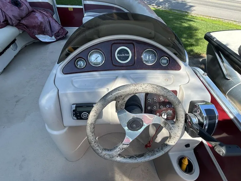 Slide: The Image of 2012 South Bay 518 CR boat dashboard with steering wheel and control panel. - 3