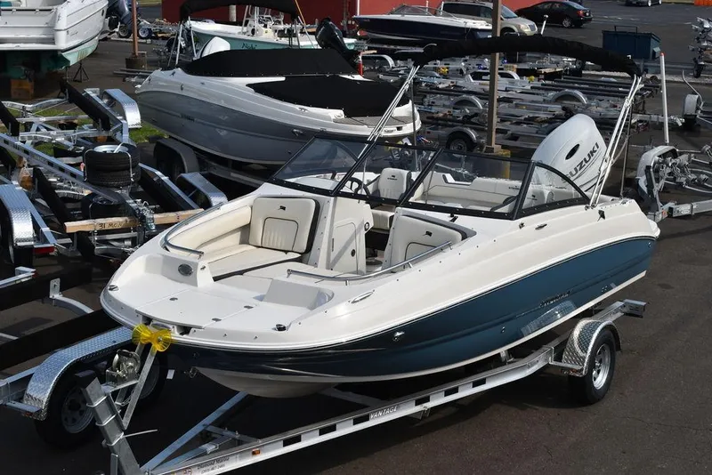 The Image of 2024 Stingray 201DC boat on a trailer in a marina. - 1