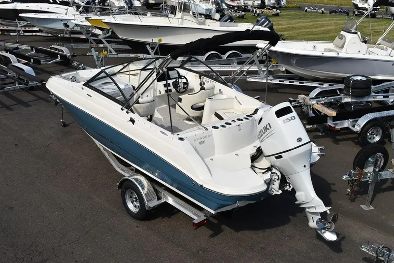 Slide: The Image of 2024 Stingray 201DC boat with Suzuki 150 outboard motor on trailer. - 11