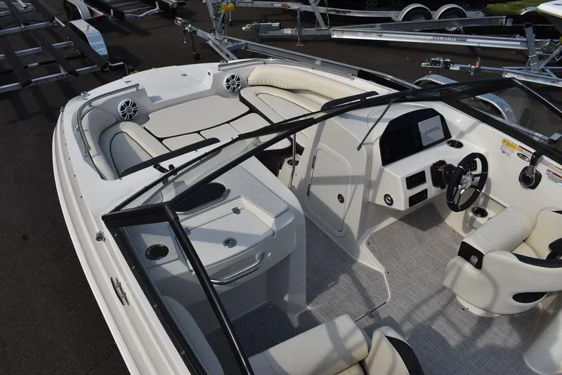 Slide: The Image of 2024 Stingray 201DC boat interior with seating, steering console, and speakers. - 12