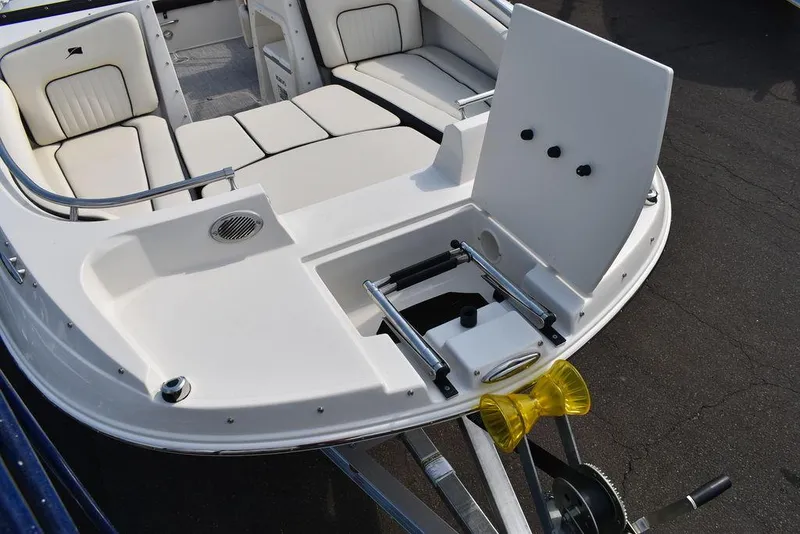 Slide: The Image of 2024 Stingray 201DC boat with open bow seating and trailer attachment. - 15