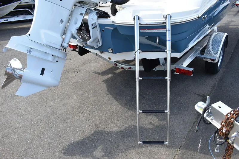 Slide: The Image of 2024 Stingray 201DC boat with ladder and outboard motor on trailer. - 17