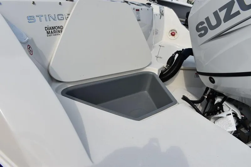Slide: The Image of 2024 Stingray 201DC boat with Suzuki engine and storage compartment. - 21