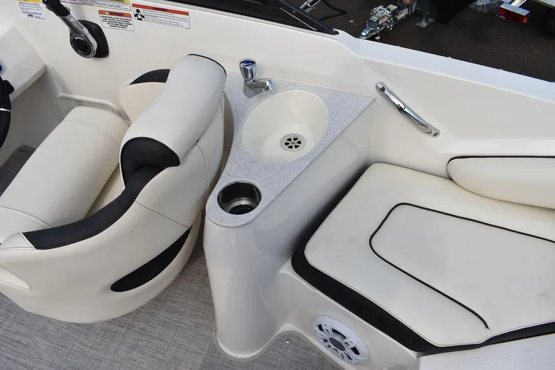 Slide: The Image of 2024 Stingray 201DC boat interior with seating, sink, and cup holder. - 23