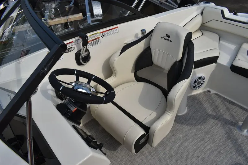 Slide: The Image of 2024 Stingray 201DC boat cockpit with steering wheel and comfortable captain's chair. - 29
