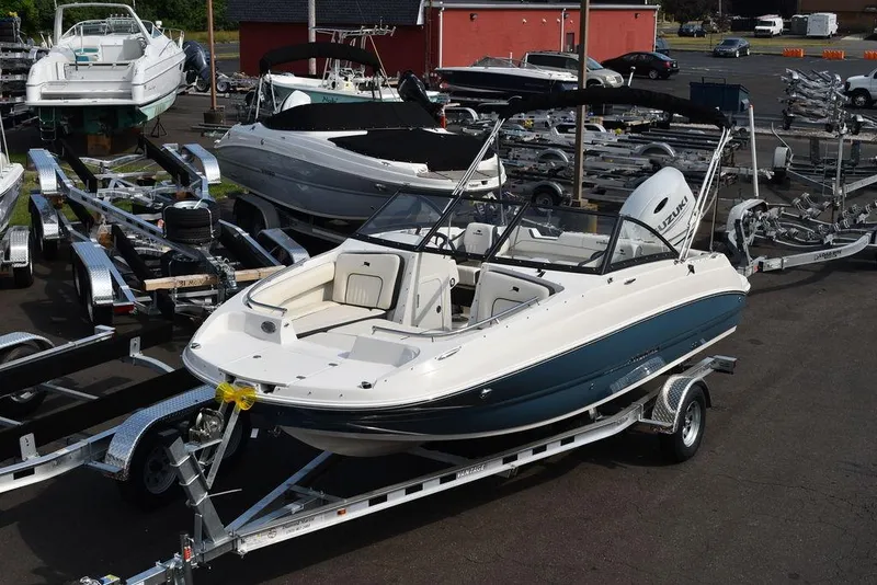 Slide: The Image of 2024 Stingray 201DC boat on trailer in marina, surrounded by other boats. - 4