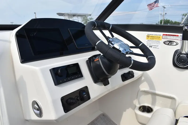 Slide: The Image of 2024 Stingray 201DC boat dashboard with steering wheel and control panel. - 43
