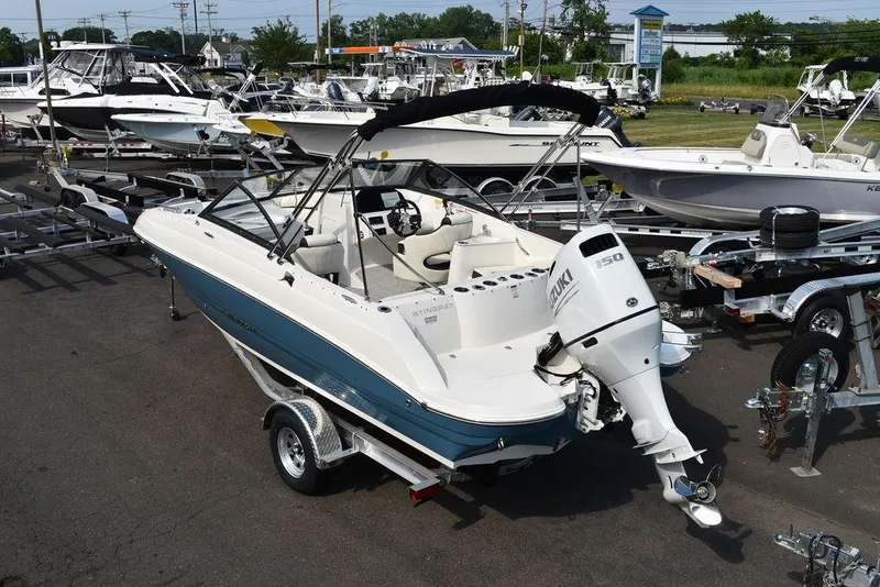 Slide: The Image of 2024 Stingray 201DC boat on trailer at marina, ready for water adventures. - 6