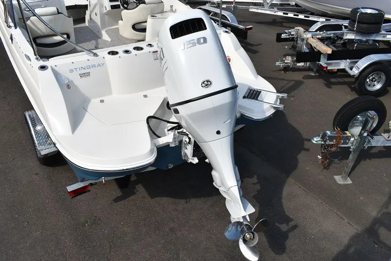 Slide: The Image of 2024 Stingray 201DC boat with 150 HP outboard motor on trailer. - 7