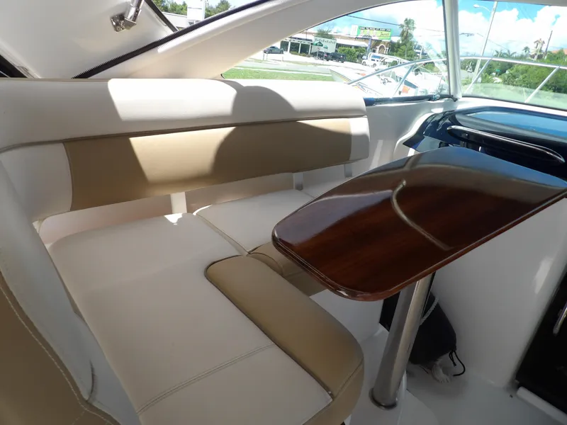 Slide: The Image of 2012 Tiara Yachts 3100 Coronet interior seating with wooden table. - 19
