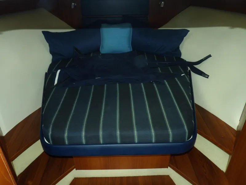 Slide: The Image of 2012 Tiara Yachts 3100 Coronet cabin with striped bedding and pillows. - 44