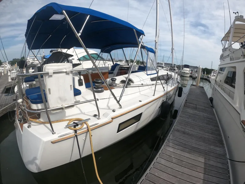 Slide: The Image of 2017 Jeanneau 54 sailboat docked at marina with blue canopy. - 10