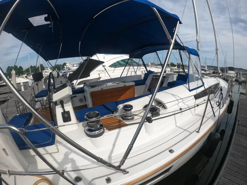 Slide: The Image of 2017 Jeanneau 54 sailboat docked at marina with blue canopy. - 11