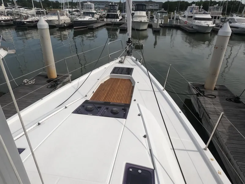 Slide: The Image of 2017 Jeanneau 54 sailboat docked at a marina, view of the bow and deck. - 14