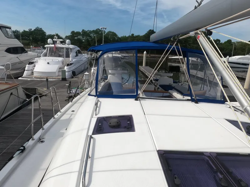 Slide: The Image of 2017 Jeanneau 54 sailboat docked at a marina, featuring a blue canopy and spacious deck. - 19