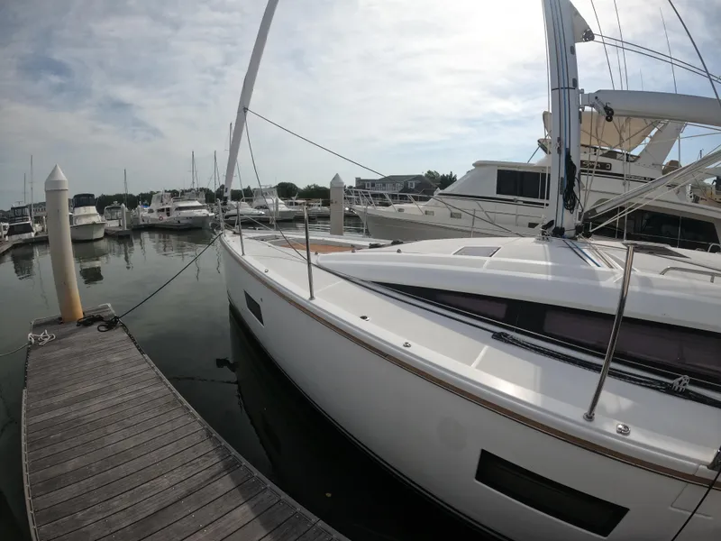 Slide: The Image of 2017 Jeanneau 54 sailboat docked at a marina with other boats. - 2