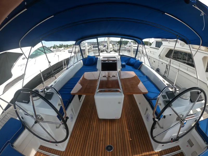 Slide: The Image of 2017 Jeanneau 54 sailboat cockpit with dual steering wheels and teak flooring. - 22
