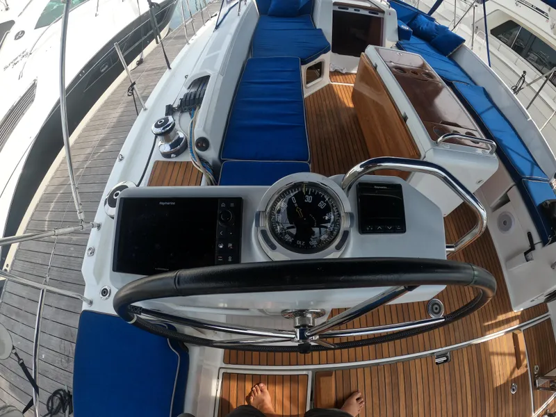 Slide: The Image of Cockpit view of 2017 Jeanneau 54 sailboat with blue cushions and navigation instruments. - 28