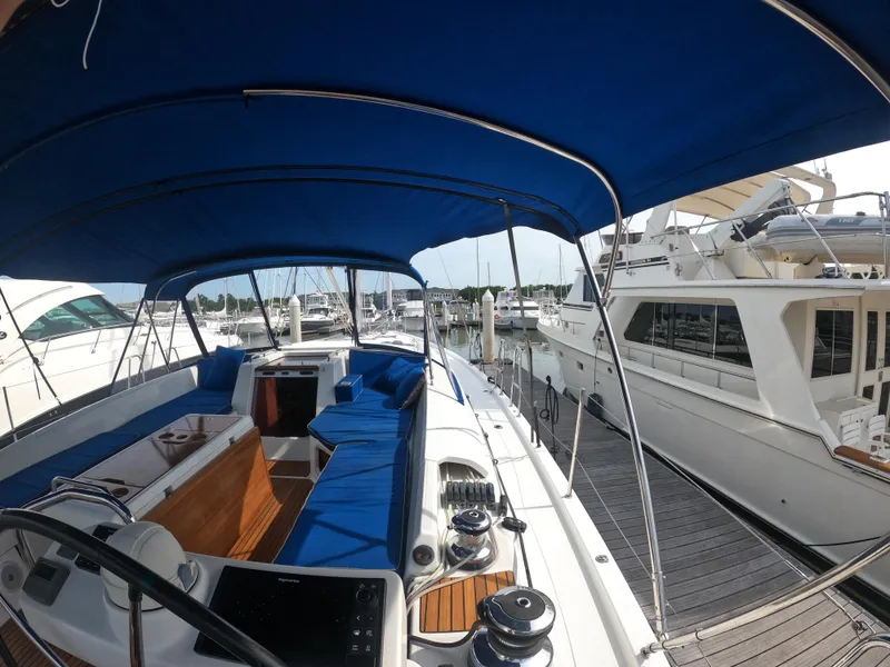 Slide: The Image of Jeanneau 54 sailboat, 2017 model, docked at marina with blue canopy and seating. - 31
