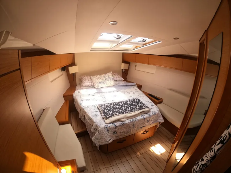 Slide: The Image of Luxurious cabin interior of 2017 Jeanneau 54 yacht with cozy bed and wooden accents. - 34