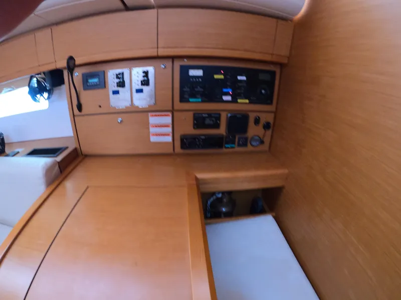 Slide: The Image of Jeanneau 54 yacht interior control panel, 2017 model, featuring wooden cabinetry and modern equipment. - 42