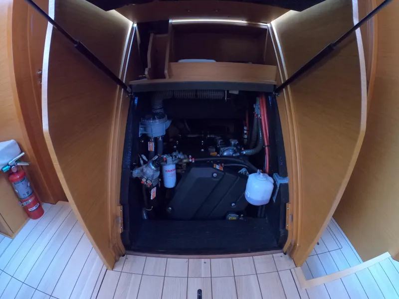 Slide: The Image of Engine compartment of 2017 Jeanneau 54 sailboat, showcasing mechanical components and storage area. - 45
