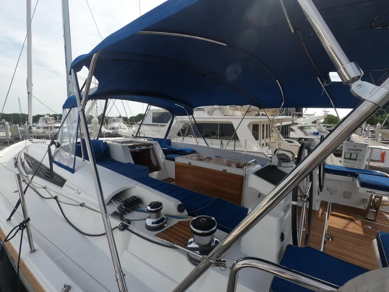 Slide: The Image of 2017 Jeanneau 54 sailboat with blue canopy docked at marina. - 7
