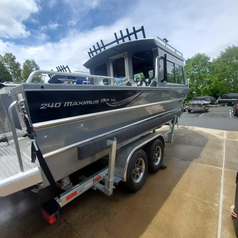 Slide: The Image of 2024 Spartan Maximus 240 boat on a trailer, parked outdoors. - 3