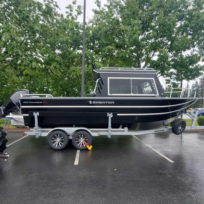 The Image of 2024 Spartan Maximus 240 boat on a trailer in a parking lot. - 1