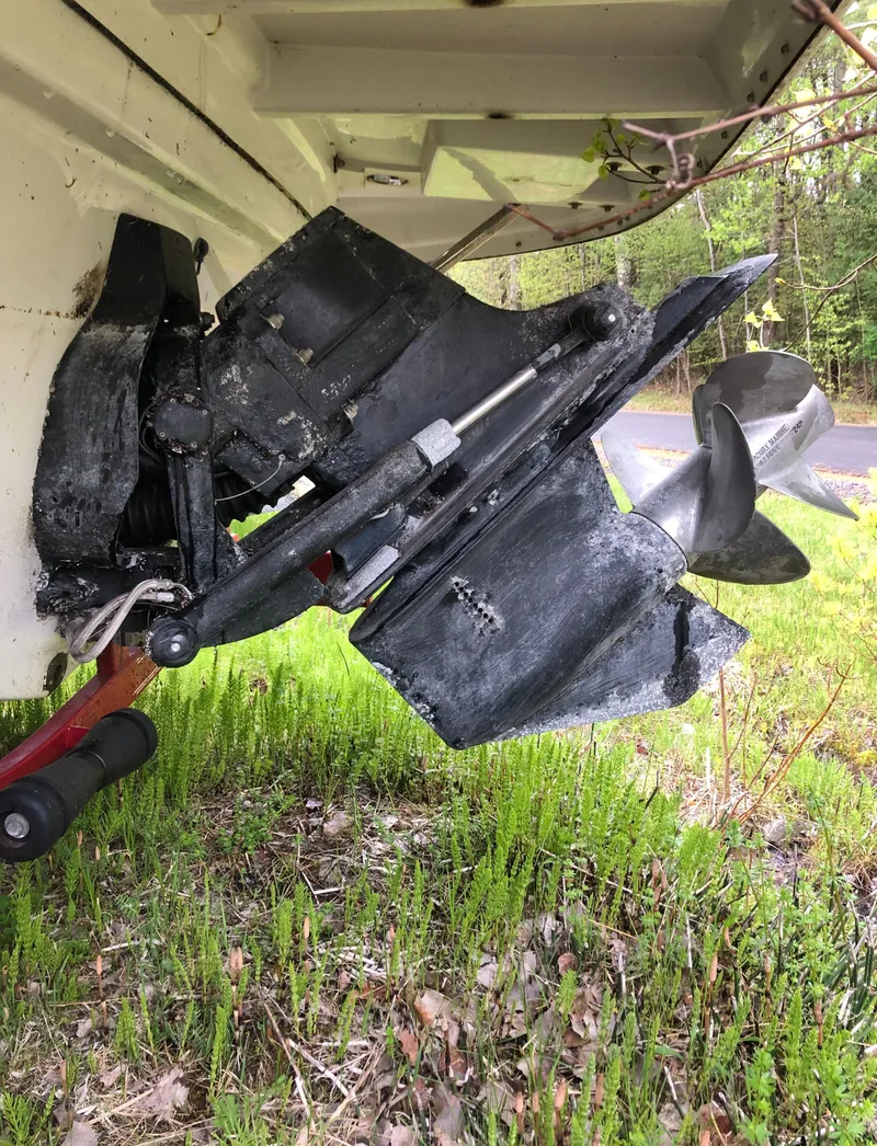 Slide: The Image of 2007 Crownline 240 EX boat outdrive in grassy area, showcasing propeller and mechanical components. - 11