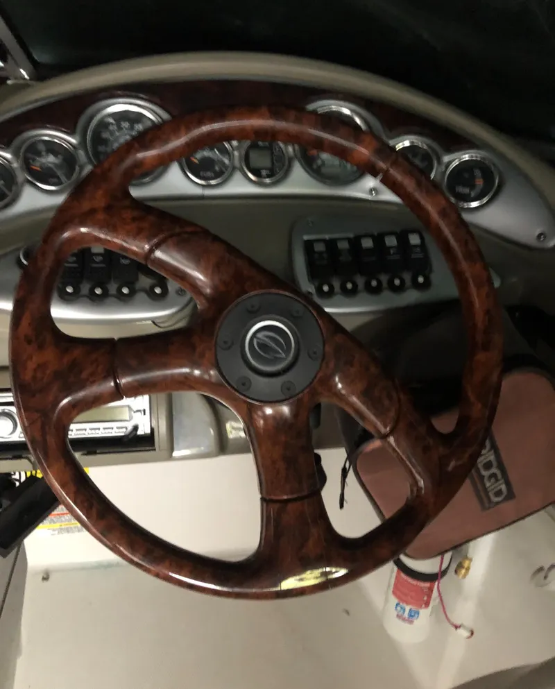 Slide: The Image of Steering wheel of a 2007 Crownline 240 EX boat with dashboard controls. - 15