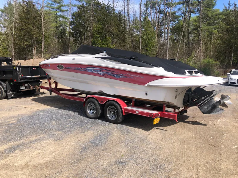 Slide: The Image of 2007 Crownline 240 EX boat on red trailer, parked outdoors. - 2