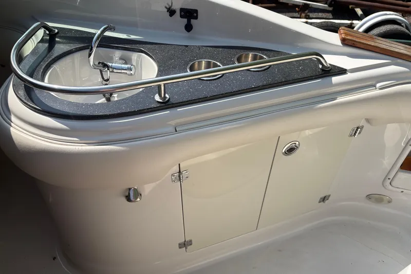 Slide: The Image of 2007 Crownline 240 EX boat interior with sink and storage cabinet. - 23