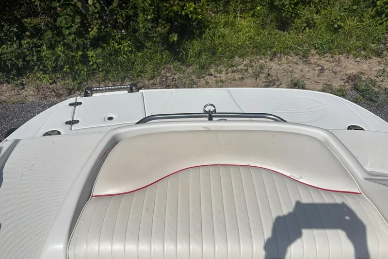 Slide: The Image of Rear view of 2007 Crownline 240 EX boat with white seating and greenery background. - 27