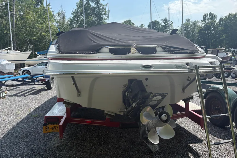 Slide: The Image of 2007 Crownline 240 EX boat on trailer, covered, with visible propeller and ladder. - 36