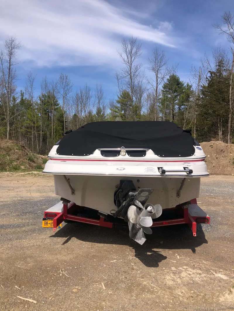 Slide: The Image of 2007 Crownline 240 EX boat on trailer, outdoors with trees and blue sky. - 9
