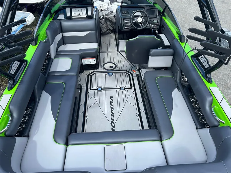 Slide: The Image of 2022 Moomba Mojo boat interior with gray and green seating and advanced dashboard. - 2