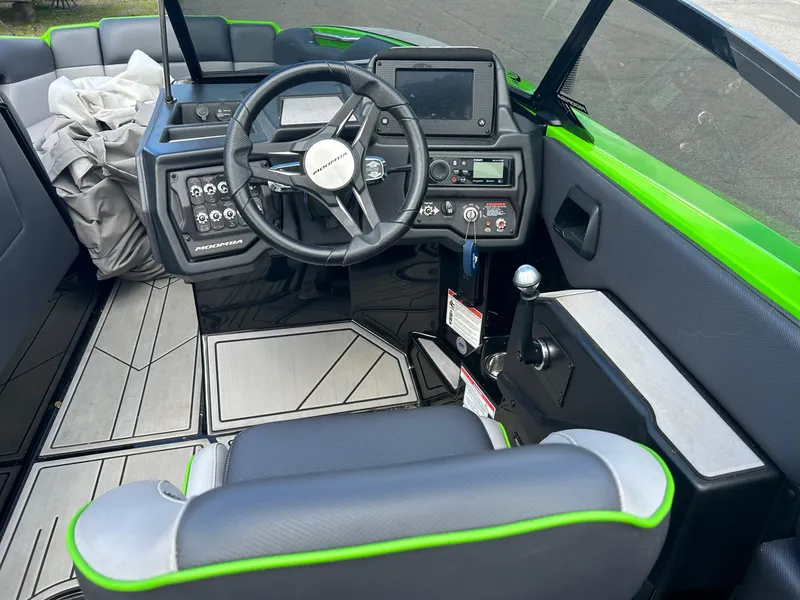 Slide: The Image of 2022 Moomba Mojo boat cockpit with steering wheel, control panel, and seating. - 4