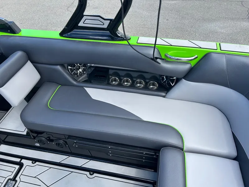 Slide: The Image of 2022 Moomba Mojo boat interior with gray and green seating and audio system. - 6