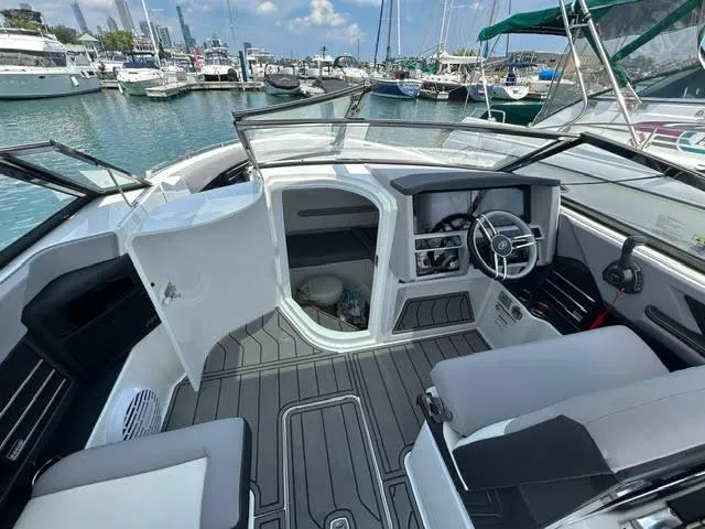 Slide: The Image of 2022 Cobalt A29 boat interior at marina with steering wheel and seating. - 11