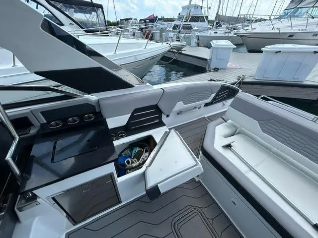 Slide: The Image of 2022 Cobalt A29 boat interior at marina, featuring seating and storage compartments. - 12