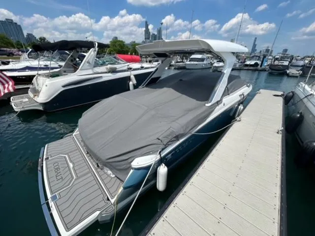 Slide: The Image of 2022 Cobalt A29 boat docked at marina, covered with a gray tarp. - 2