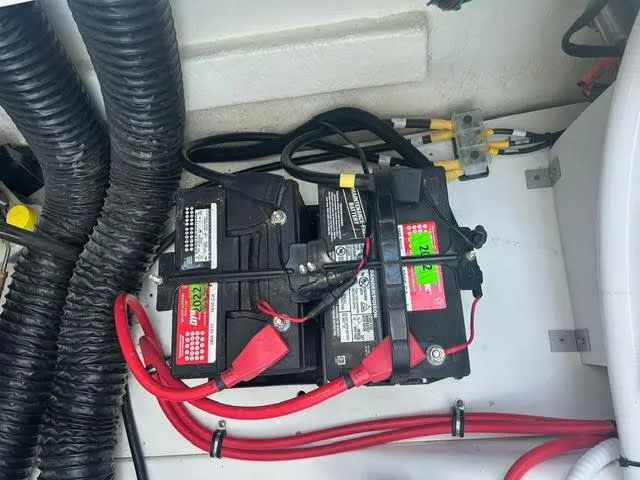 Slide: The Image of 2022 Cobalt A29 boat battery compartment with dual batteries and wiring. - 23