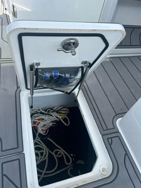 Slide: The Image of Open storage compartment on a 2022 Cobalt A29 boat with ropes inside. - 29