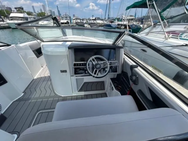 Slide: The Image of 2022 Cobalt A29 boat interior with steering wheel and dashboard at marina. - 7