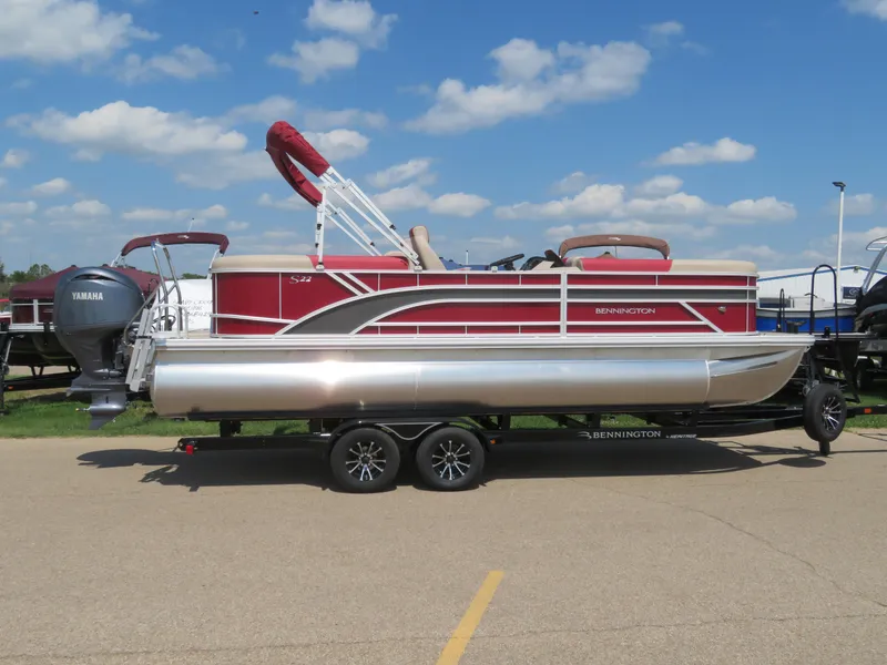 Slide: The Image of 2024 Bennington 22SSR pontoon boat on trailer under blue sky. - 1